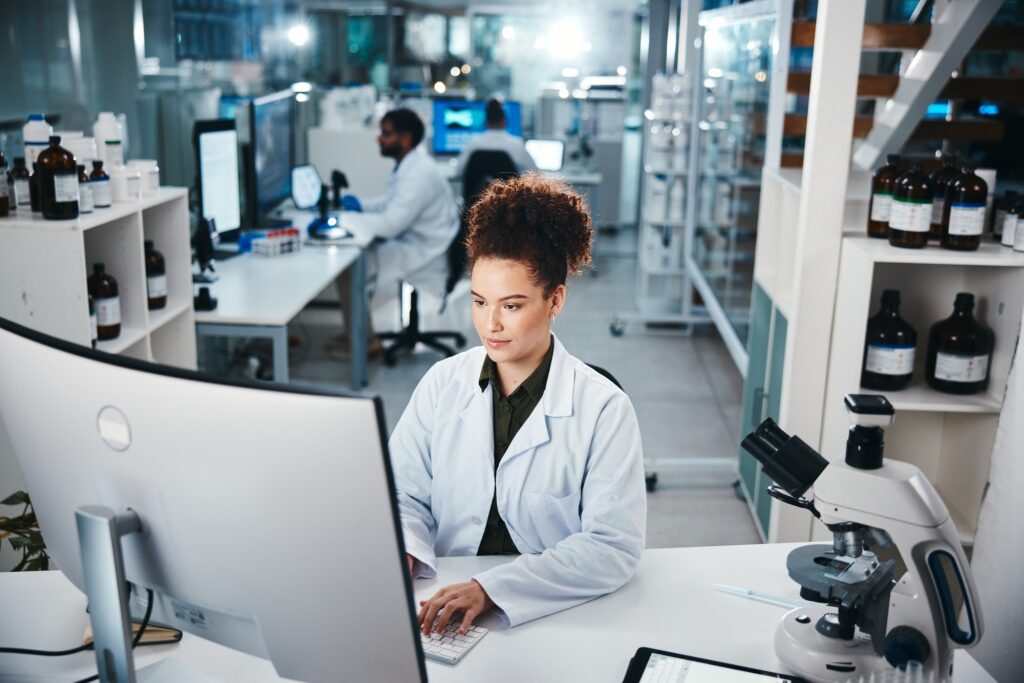 Computer, report and science with woman in laboratory for development, innovation or research. Desk
